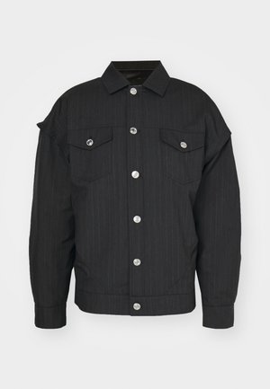 Chaqueta negra de rayas con textura, que presenta un cuello, dos bolsillos en el pecho y botones a presión plateados en el frontal.