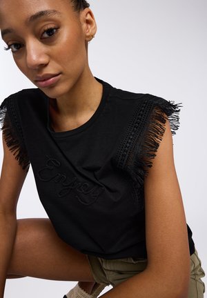 Maglietta nera con dettagli di frange e testo ricamato "Enjoy" sul fronte. Tessuto morbido con bordo testurizzato sulle maniche.