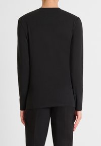 Schwarzes langärmeliges T-Shirt mit Rundhalsausschnitt, aus glattem Stoff gefertigt, mit geradem Saum und bequemem Schnitt. Keine sichtbaren Grafiken oder Muster.