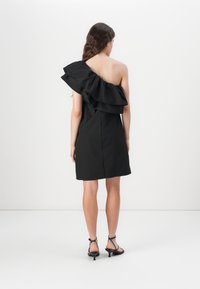 Svart off-shoulder kjole med lagdelt volang. Laget av teksturert stoff, har den en tettsittende bol og en A-linje silhuett.