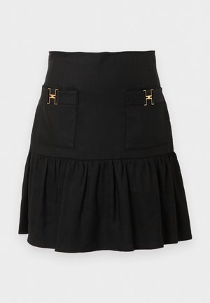 Μαύρη φούστα με ψηλόμεση μέση, εμπρόσθιες τσέπες με χρυσές αγκράφες "H" και τελείωμα με ρευστή βολάν.