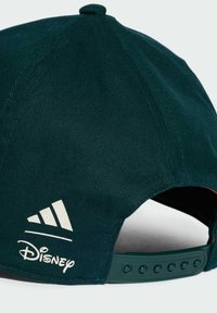 Gorra verde oscuro con textura estriada, con los logotipos blancos de Adidas y Disney, cierre de plástico tipo snapback y parte superior redondeada.