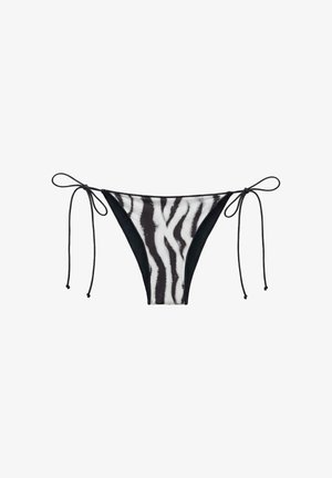 Slip bikini con stampa zebra bianco e nero con laccetti laterali regolabili, mostrato su sfondo bianco.