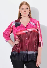 Blusa a righe rosa e rossa con colletto, chiusura a bottoni e maniche a tre quarti, con un motivo sfumato che transita verso tonalità scure.