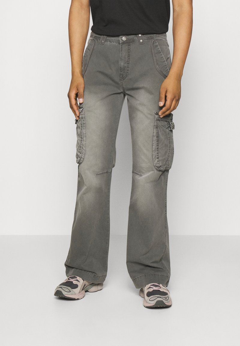 Graue Cargo-Hosen mit ausgestelltem Schnitt, großen seitlichen Taschen, Knopfleiste und kontrastierender Naht. Strukturierter Baumwollstoff.