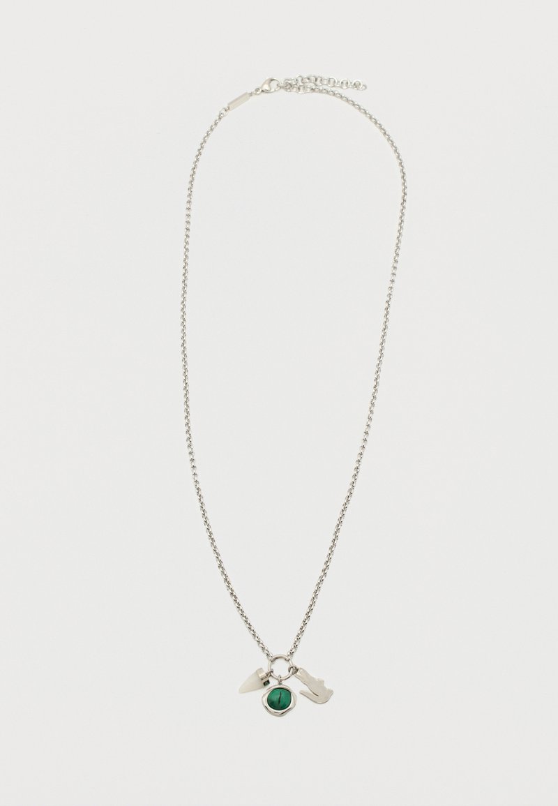 Collar de cadena plateada con tres dijes: un cuerno blanco, una piedra verde en un marco plateado y un dije plateado en forma de guitarra.