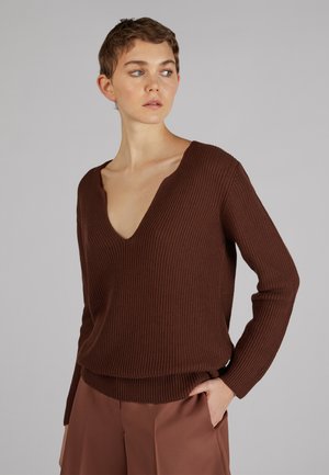 Brauner gerippter Strickpullover mit tiefem V-Ausschnitt und langen Ärmeln; hat einen lockeren Schnitt und einen leicht taillierten Saum.