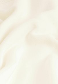 Cremefarbener Stoff mit einer weichen, glatten Textur, der subtile Falten und ein leichtes Aussehen aufweist, geeignet für Kleidung oder Polsterung.