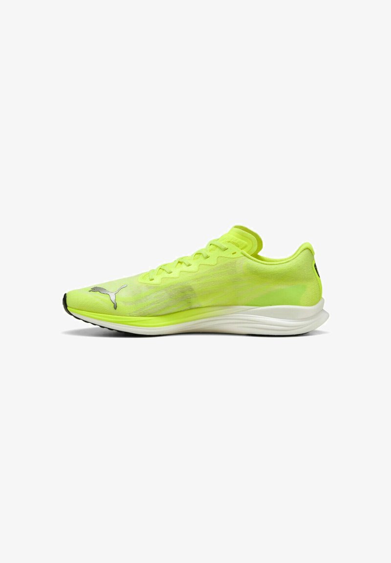 Scarpa da corsa gialla brillante con un design leggero, tomaia testurizzata, forma stretta e suola bianca con accenti neri e branding.