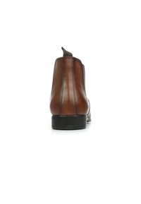 Bottines en cuir marron avec une texture lisse, des panneaux latéraux élastiques et une petite languette à l'arrière. Semelle en caoutchouc noir plat.