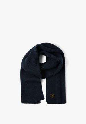 Marineblauwe geribbelde gebreide sjaal met een zachte textuur. Voorzien van een geweven label in de hoek met merkdetails. Lange, veelzijdige ontwerp.