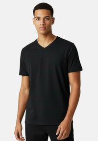 Svart T-shirt med V-ringning i mjukt tyg, korta ärmar och figurnära passform. Enkel design utan mönster eller extra detaljer.