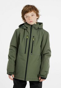 Veste isolée verte avec capuche, zips noirs, poches poitrine et frontales, et poignets réglables. Fabriquée en matériau imperméable et comporte des détails de logo.