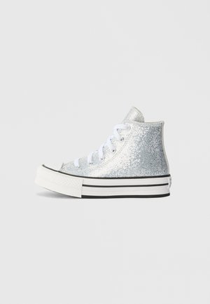 Silberne High-Top-Sneaker aus glitzerndem Material, mit weißen Schnürsenkeln und einer schwarz-weißen gestreiften Sohle. Sie haben eine abgerundete Zehenpartie und eine feste Ferse.