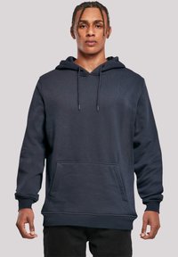 Navy blue hoodie made of cotton with a kangaroo pocket, drawstring hood, ribbed cuffs, and textured surface.
