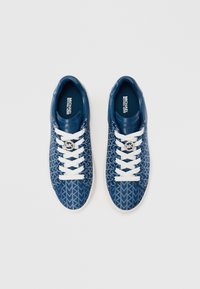 Blå mønstrete joggesko med geometrisk design, hvite lisser og tonale merkinger. Laget av syntetisk materiale med gummisåle.