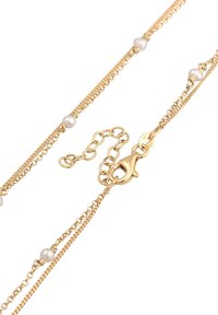 Gouden ketting met drie kettingstrengen met witte ronde parels en een kreeftsluiting voor een veilige bevestiging.