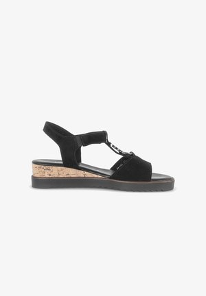 Black suede wedge sandal with cork midsole, adjustable ankle strap, and decorative silver chain detail on upper straps.