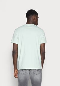Puma PUMA HARIBO GRAPHIC TEE - Triko s potiskem - gossamer green