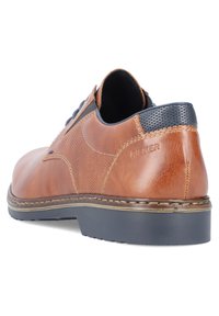 Scarpa in pelle marrone con un design testurizzato, chiusura con lacci e accenti blu a contrasto sul tallone. Suola in gomma con dettagli di cucitura.
