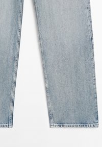 Pantalon en jean bleu clair avec ourlets droits sur fond blanc, montrant les détails de la texture et des coutures.