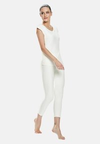 Hvid, tætsiddende top med korte ærmer og rund hals, parret med matchende hvide leggings. Begge beklædningsgenstande har en glat tekstur.