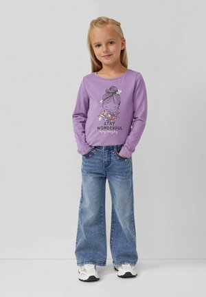 Paarse longsleeve shirt met een afgedrukt ontwerp van een meisje en de tekst "STAY WONDERFUL", gecombineerd met blauwe wijde jeans en witte sneakers.