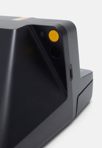 Compact black device with a matte finish, featuring a yellow power button, a camera lens, and a USB-C port on the side.