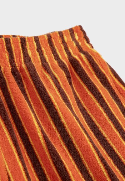 Shorts à taille élastique avec des rayures verticales en tissu éponge orange, marron et jaune, présentés sur un fond uni.