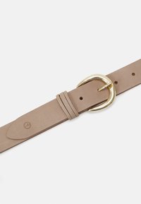 Ceinture en cuir tan avec une boucle ronde en ton doré, comportant plusieurs trous et une texture lisse. Logo embossé sur le cuir.