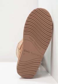Suela de goma marrón resistente al agua con patrón texturizado. Presenta la marca "EMU Australia" y un diseño moldeado para ofrecer agarre.