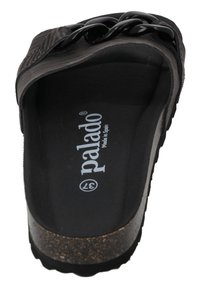 Zwarte slipper met een gestructureerde stoffen band, overladen met een zwarte kettingdetail, een gevoerde voetbed en een kurkachtige zool. Merken "Palado" aan de binnenkant.