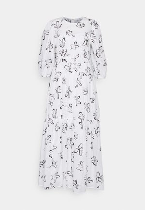 Robe blanche longueur cheville avec imprimé floral noir. Elle a un col rond et des manches bouffantes, avec une taille froncée et une jupe à volants.