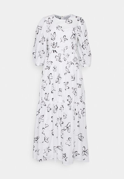 Λευκό φόρεμα до τον αστράγαλο με μαύρη λουλουδένια εκτύπωση. Διαθέτει στρογγυλή λαιμόκοψη και φουσκωτά μανίκια, με προσαρμοσμένη μέση και φούστα με στρώσεις.