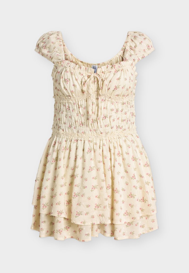 Φόρεμα σε εκρού χρώμα με μικρό ροζ λουλουδένιο μοτίβο, κοντά μανίκια με βολάν, στήθος με πιέτες και φούστα με στρώσεις και δέσιμο μπροστά.