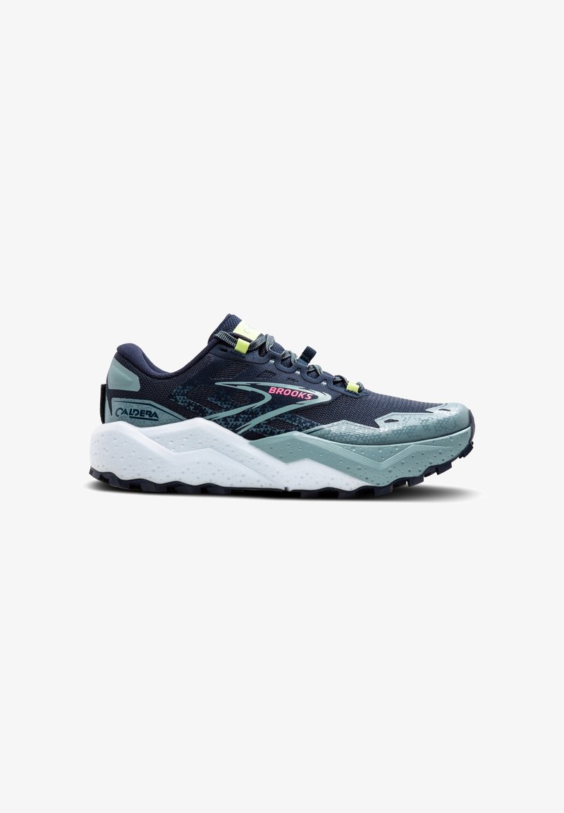 Chaussure de trail running avec un dessus en maille bleu marine, des accents vert menthe, une semelle en caoutchouc texturée et un intercalaire zigzag blanc. Présente une protection renforcée au niveau des orteils.