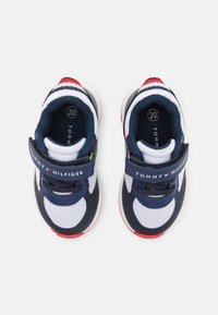 Sneaker in rete blu navy e bianco con accenti rossi, dotati di una fascia, dettaglio del logo e una suola testurizzata per una buona aderenza. Taglia segnala come 20.