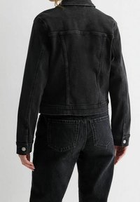 Svart denimjacka med en figursydd design, synlig söm, silverfärgade knappar och en något croppad längd. Texturerad tyg.