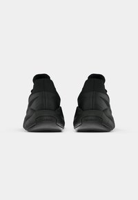 Juodos sportinės bateliai su tekstūruota viršutine dalimi, paminkštintu apykaklės kraštu ir tvirtu padu. Išskirtinė glotni apdaila ir Reebok ženklas ant kulno.