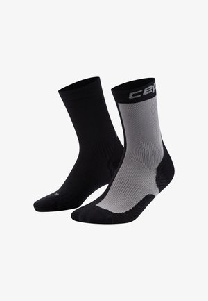 Schwarz-graue Knöchelsocken mit gerippter Textur, verstärkten Fersen und Zehenbereichen. Mit kontrastierenden Farbkombinationen und Logo am Bündchen.
