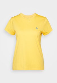 Gul bomull T-shirt med kort ärm och rundad halsringning. Har en liten blå broderad logotyp på vänster bröst.