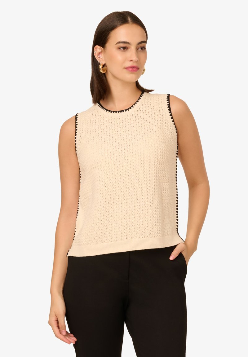 Beige gestricktes ärmelloses Oberteil mit schwarzem Besatz entlang des Ausschnitts und der Armausschnitte, mit einem strukturierten Muster und einem lockeren Schnitt.