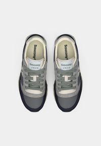 Sneakers in tessuto grigio con suola blu navy, caratterizzati da una texture liscia, punta rotonda e design con lacci. Accentuati da dettagli bianchi e grigi chiari.
