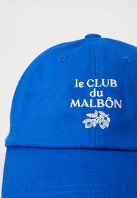 Modra bejzbolska kapa iz bombaža, ki ima na sprednji strani brodiran bel napis "le CLUB du MALBÒN" in grafiko lista.