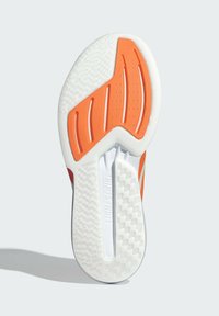 Suela de zapato con una base blanca con surcos texturizados, acentos naranjas y patrones geométricos para tracción. Incluye el logo "LIGHTSTRIKE".