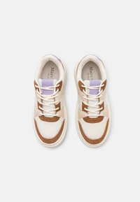Sneakers z kremową siateczką, brązowymi zamszowymi akcentami, białymi sznurówkami i fioletowym uchwytem na pięcie. Okrągły czubek i masywna biała podeszwa.