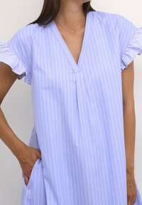 Light purple dress with white vertical stripes, short ruffled sleeves, V-neckline, and side pockets. Soft fabric and relaxed fit.