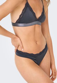 Grijze bralette met kantafwerking en bijpassende bikini slipjes, voorzien van een zacht materiaal, delicate kantaccenten en een strak, minimalistisch ontwerp.