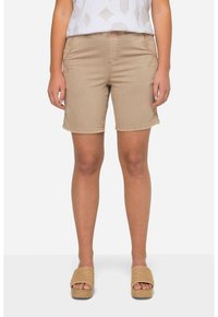 Pantaloni corti beige in tessuto liscio, con tasche frontali e cuciture a vista. Abbinati a sandali con plateau color sabbia.