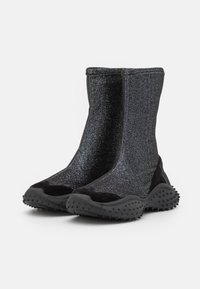Stivali neri alla caviglia realizzati in tessuto luccicante con una texture liscia e suola in gomma dotata di piccole punte. Design elegante con una forma aderente.